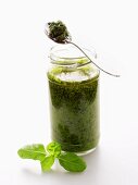 A Jar of Pesto with Spoon and Basil Leaf
