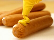 Squeezing Mustard onto a Hot Dog