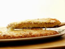 Käsepizza mit Stück auf Heber