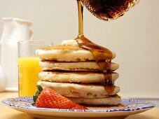 Pouring Syrup Over a Stack of Pancakes