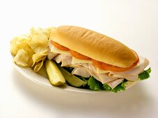 A Turkey Sub with Chips and Pickles