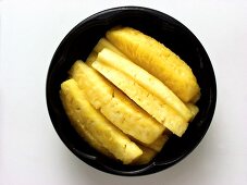 Geschnittene Ananas in schwarzer Schale