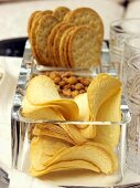 Chips, Erdnüsse und Cracker in Glasschalen