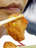 Asiatin isst Chicken Nugget