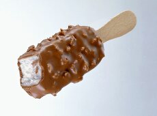 Chocolate and nut coated vanilla ice cream, a bite taken