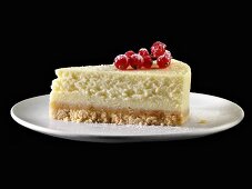 A piece of New York cheesecake with redcurrants