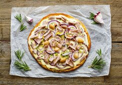 A pizza with tuna, onions and white beans