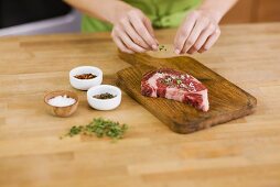 Woman Seasoning a Steak