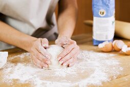 Woman Preparing Dough on a Floured Surface in Kitchen