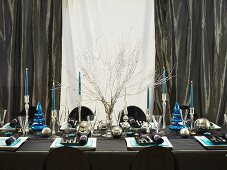 A festively laid Christmas table in blue and silver