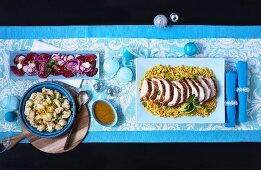 Maroccan roast turkey in slices on couscous with cauliflower and salad (viewed from above)