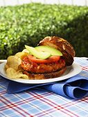 Chicken burger with tomatoes, avocados and potato chips