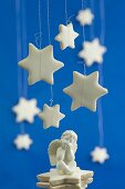 Cinnamon stars hanging above a seated angel figurine
