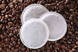 Three coffee pads on coffee beans