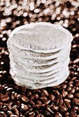 A stack of coffee pads on coffee beans