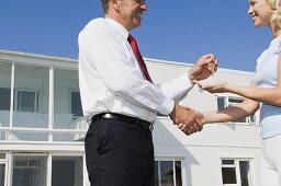 A woman and an estate agent shaking hands