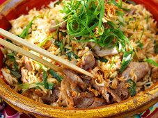 Nasi goreng with meat & spring onions in terracotta bowl