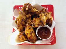 Barbecued chicken wings in plastic basket