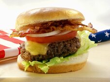 Hamburger with bacon in front of American flag