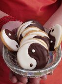 Asian woman holding dish of Yin Yang biscuits