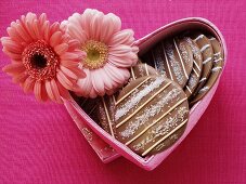 Chocolate cookies in heart-shaped box with flowers