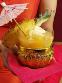 Woman holding golden bowl of Thai sangria