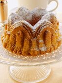 Small fruit cake with icing sugar on cake plate