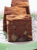 Brownies with walnuts on green cake plate