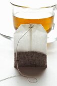 Tea bag in front of a cup of tea