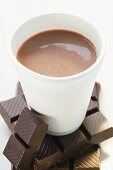 Cocoa in paper cup on pieces of chocolate