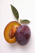 Plum, halved, with drops of water