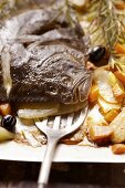 Turbot with carrots and potatoes on baking tray