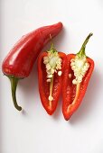 Two red chili peppers, one halved