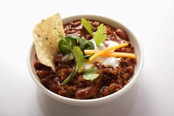 Chili con carne with cheese, sour cream and tortilla chips
