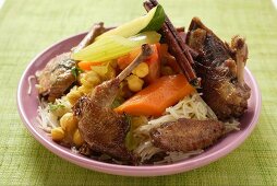 Roast pigeon with vegetables and cinnamon sticks on noodles