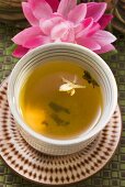 Jasmine tea in small bowl in front of water lily