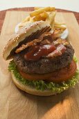 Hamburger mit Bacon, Ketchup und Pommes frites