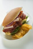 Salami, ham, cheese and salad sandwich with crisps