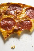 Piece of salami and cheese pizza, bites taken