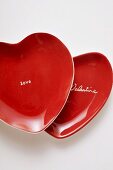 Rote herzförmige Teller mit Schrift Be my Valentine und Love