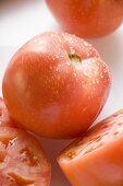 Tomaten, ganz, halbiert und Scheiben, mit Wassertropfen