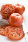 Tomatoes, whole, halved and slices, with drops of water
