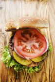 Selbstgemachter Hamburger mit Essiggurken, Zwiebeln, Tomate