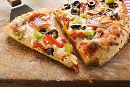 Pizza mit Peperoniwurst, Paprika und Oliven