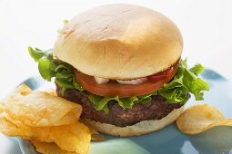 Hamburger mit Tomate, Zwiebeln, Ketchup und Chips