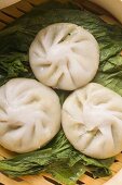 Three filled yeast dumplings on pak choi (Thailand)