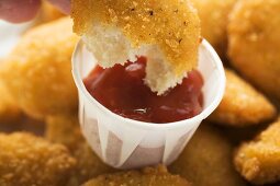 Dipping a chicken nugget in ketchup