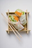 Two Vietnamese rice paper rolls with chopsticks