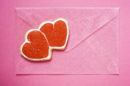 Rosa Briefumschlag mit roten Mürbteigherzen