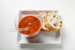 A glass of pepper & vegetable smoothie with straw & white bread